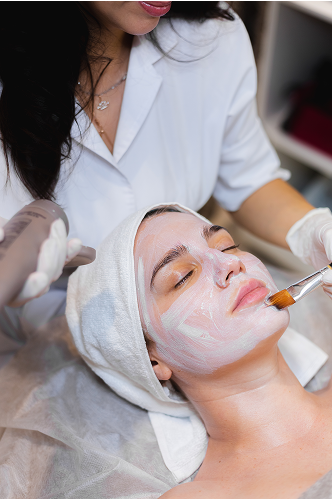beautician-with-brush-applies-white-moisturizing-mask-face-young-girl-client-spa-beauty-salon